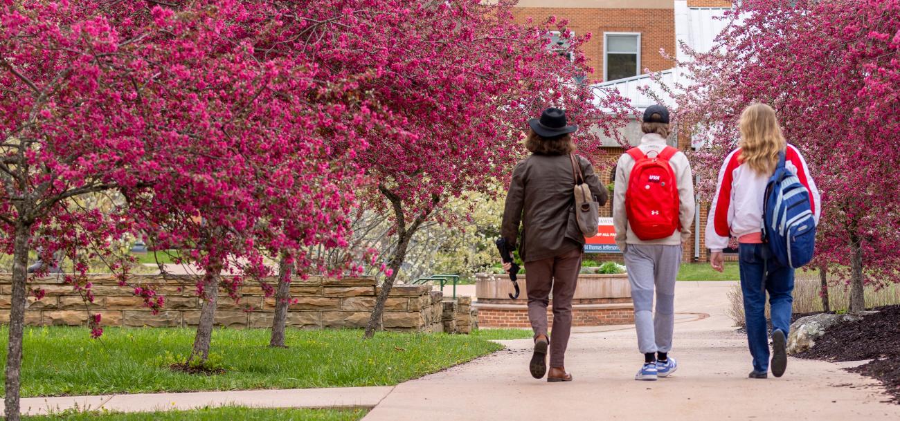 Students walking on campus with backpacks