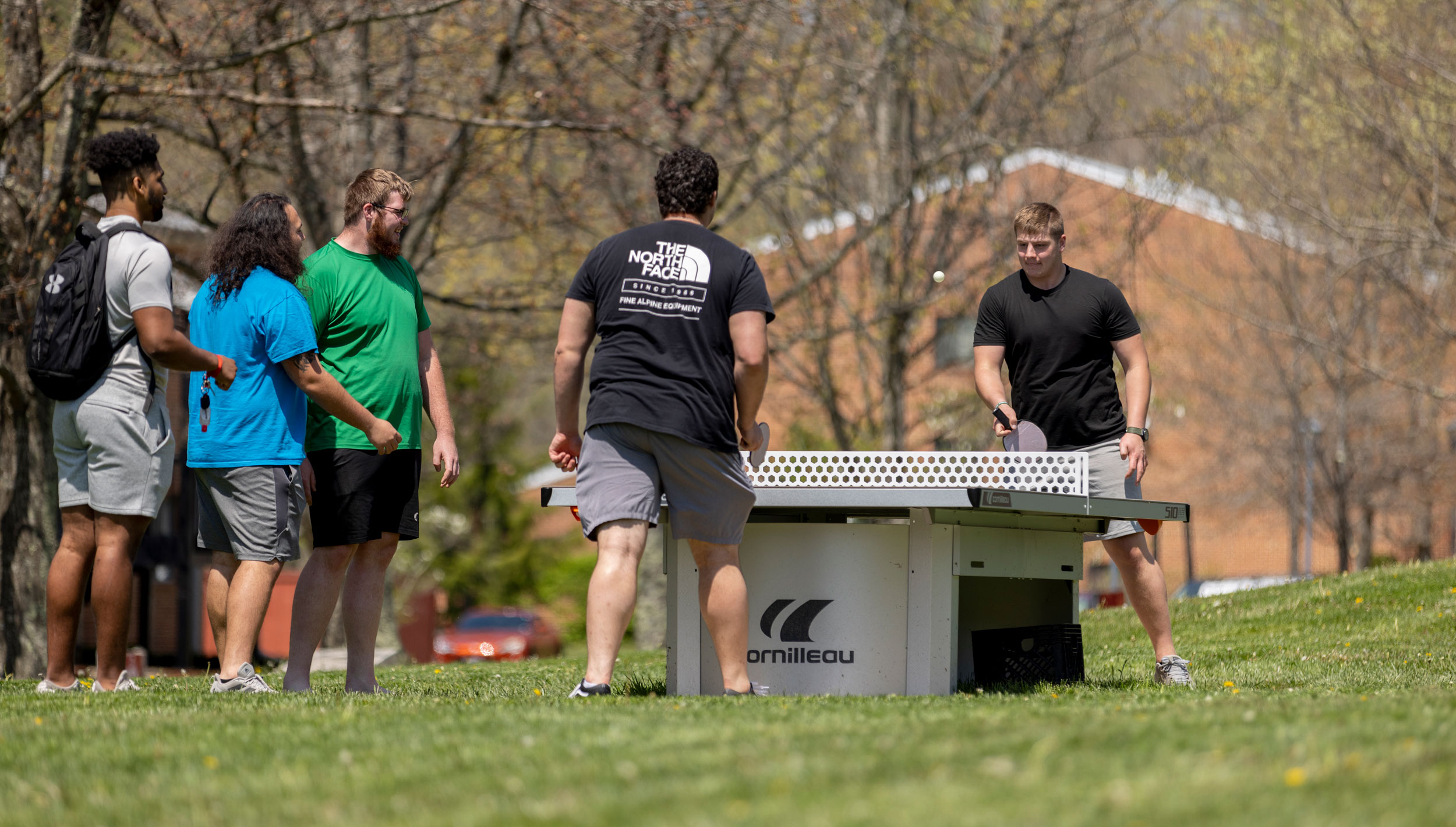 Students playing ping pong outside