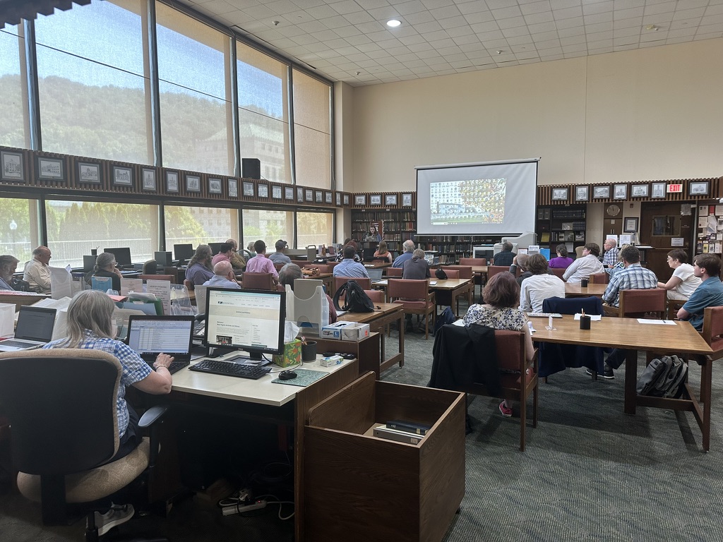 Person presenting with attendees sitting at tables