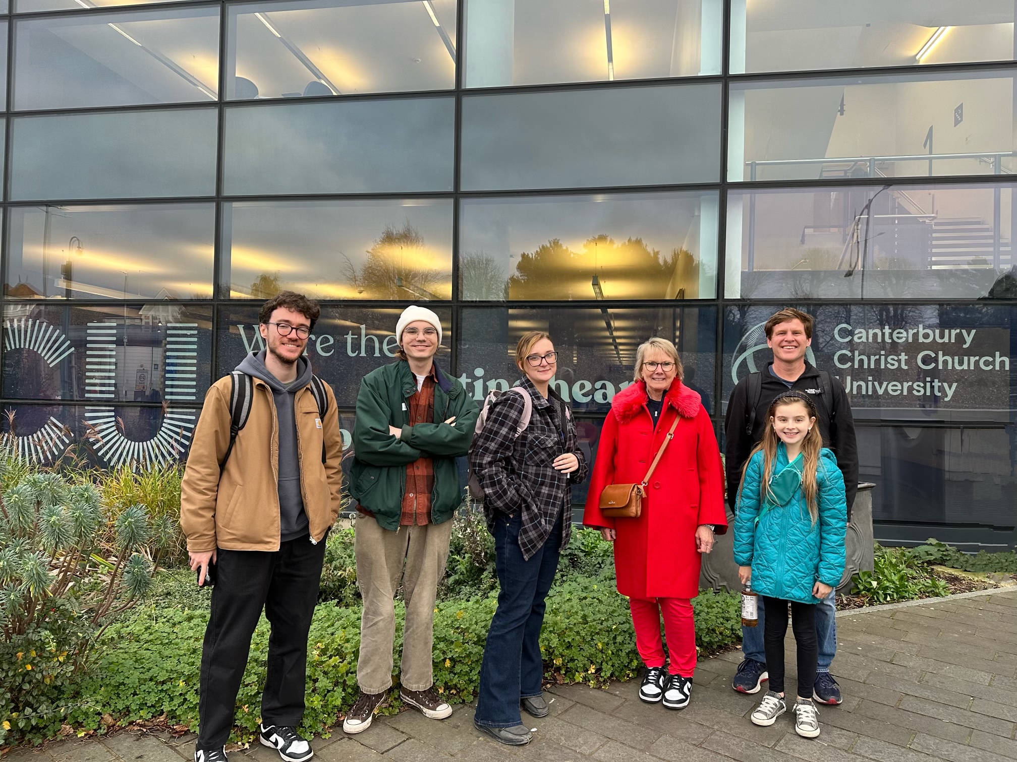 Chancellor posing in front of Canterbury Christ Church University with students