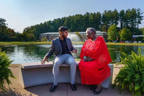 Sanjeev Kumar and Sandra Jones sitting on newly dedicated bench by the lake