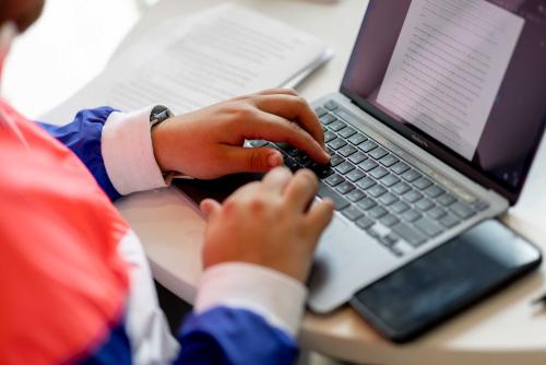 Hands typing on laptop