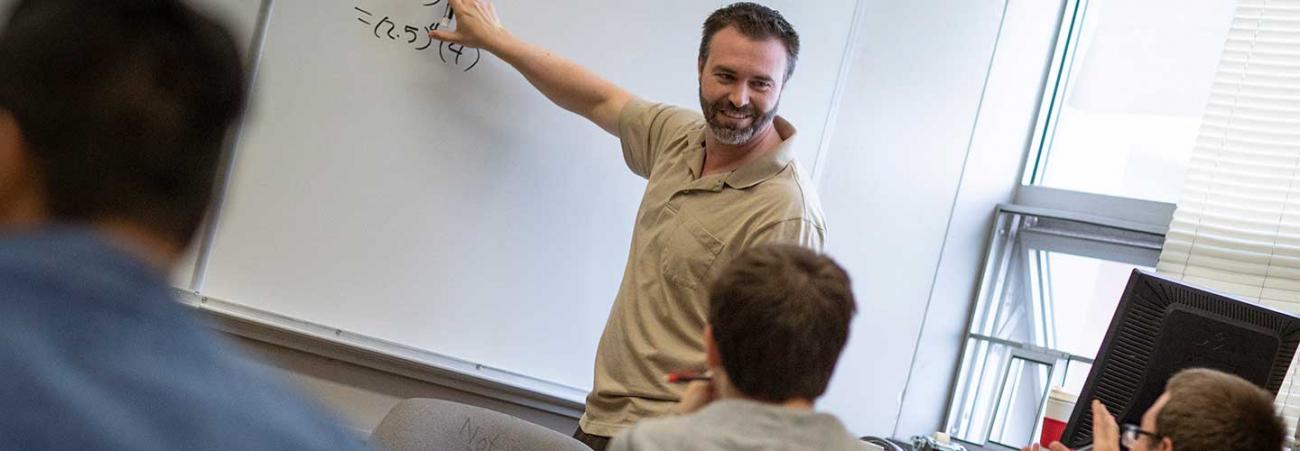 Professor at white board in math class